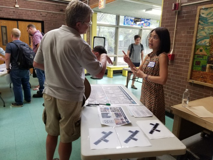 CDOT staffer Huan Hui discusses the planned changes with a resident. Photo: Coco Johnson