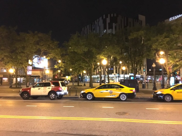 Despite "Bus Lane" street markings and signs, taxi drivers are still parking in the former cab stand location. Photo: Steven Vance