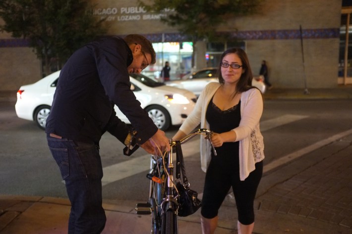 A volunteer installs a bike light at a "Get Lit" event in Pilsen. Photo: Steven Vance