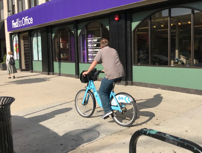 A Divvy rider bikes on the sidewalk at Division and Dearborn. Photo: John Greenfield