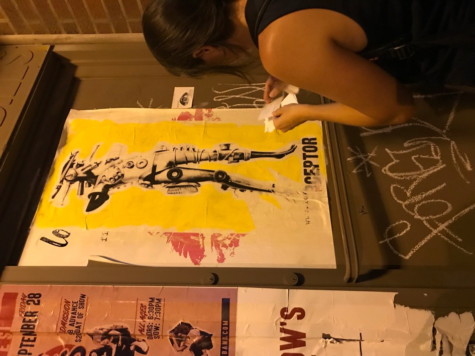 Elizabeth Tieri puts up "EVERYWHERE" Stickers. Photo: Lynda Lopez