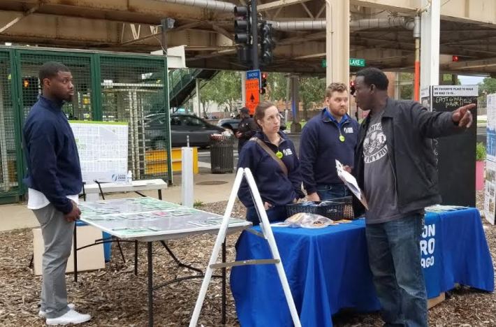 A resident discusses traffic safety issues with Vision Zero staff at a Light the Night event at Lake/Kedzie. Photo: CDOT