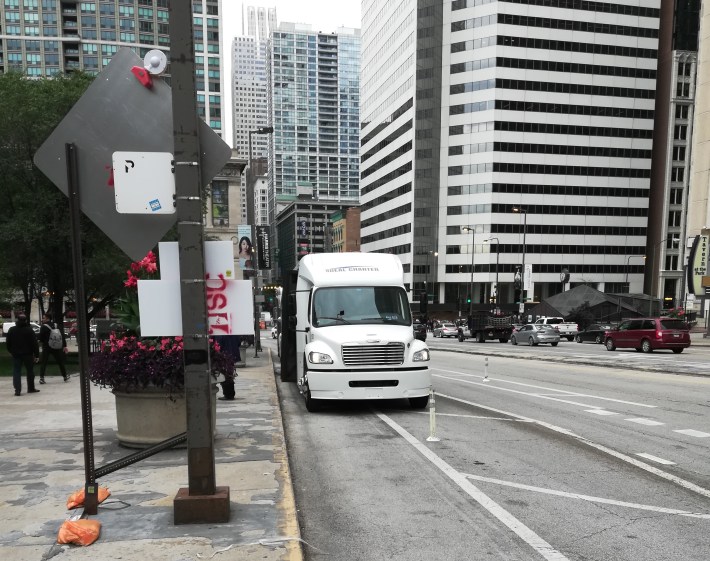 A chartered mini-bus parked in the curbside lane on Friday.