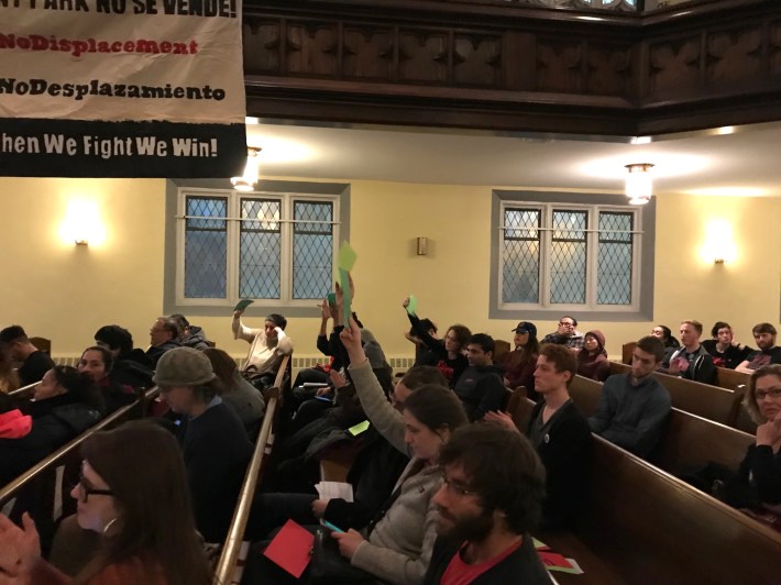 Audience members hold up green cards to agree with one of the candidate's statements. Photo: John Greenfield