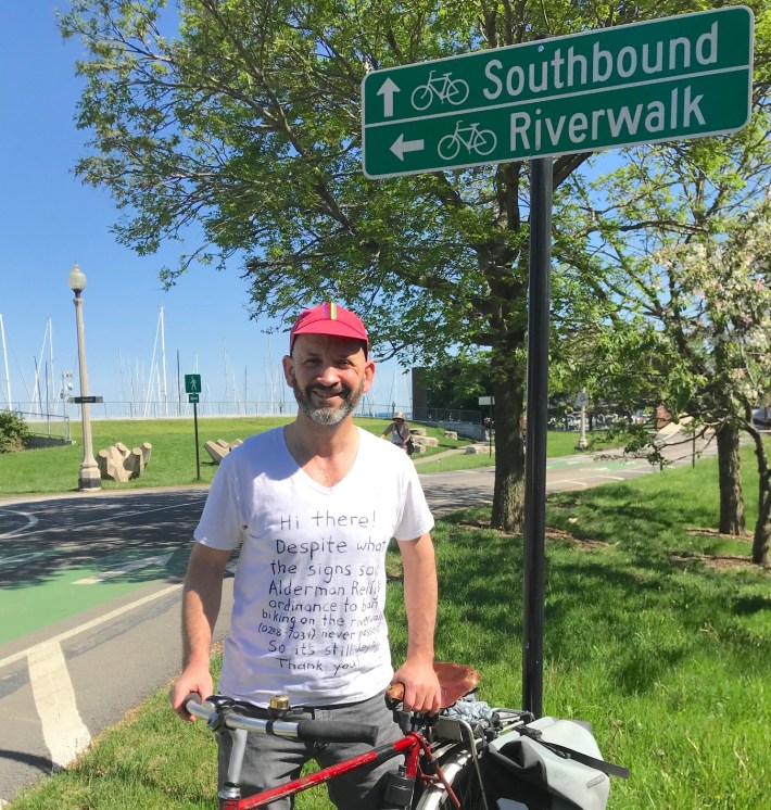 Getting ready to ride beneath a sign directing cyclists to the riverwalk -- where guards tell them they can't cycle. Photo: Victor Herrera.