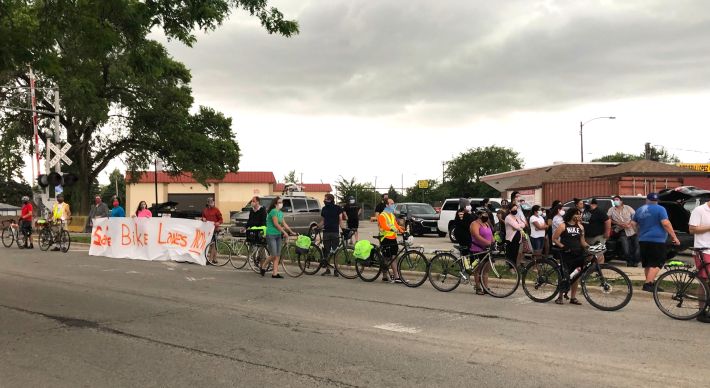 The human-protected bike lane with a banner reading "Safe Bike Lanes Now." Photo: Mia Park