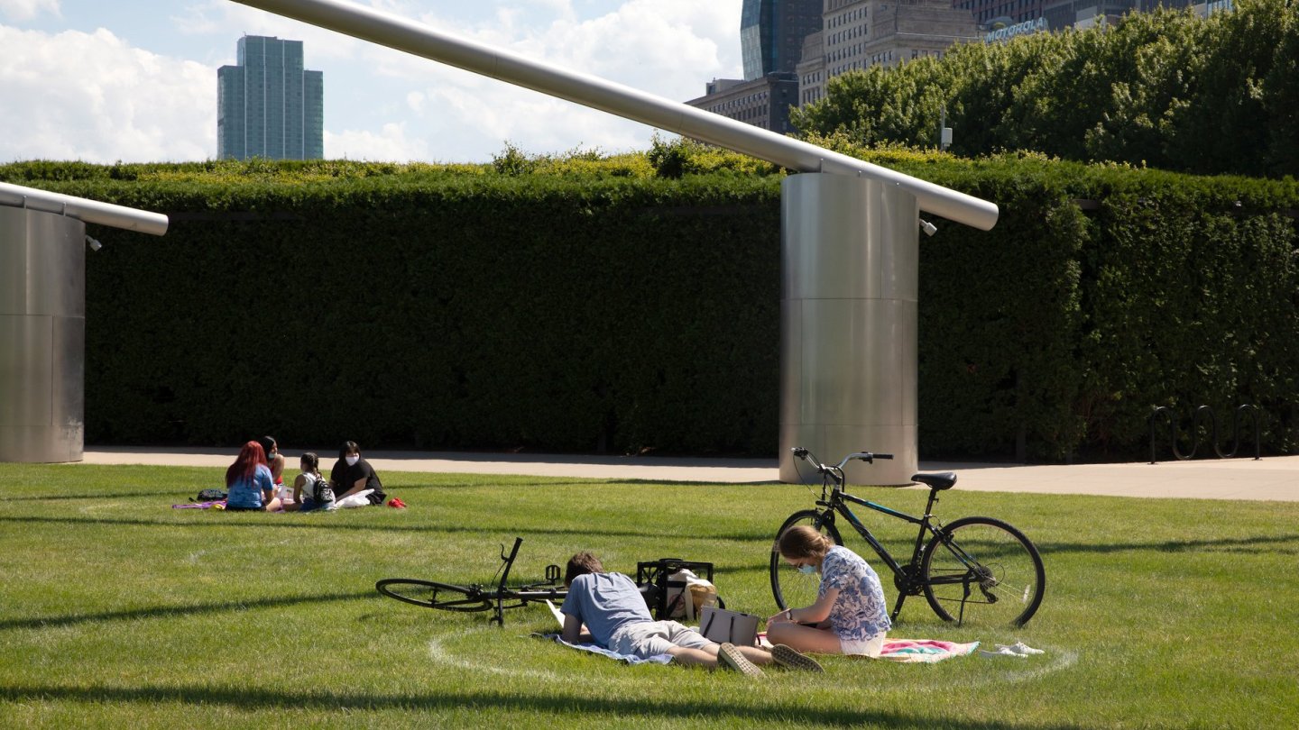 People sit on the Millennium Park lawn inside distancing circles