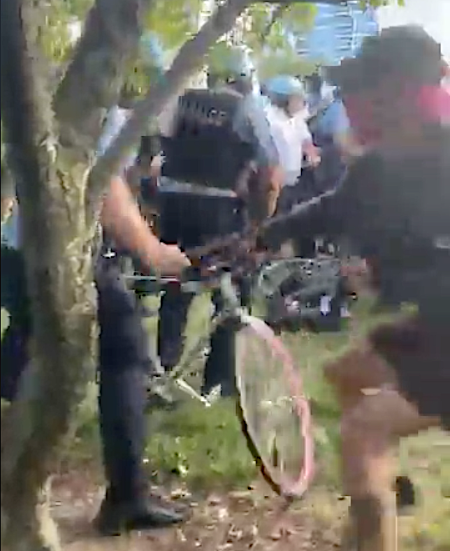 A cop seizes a protester's bike. Still from a video posted by Facebook user humboldtpark.