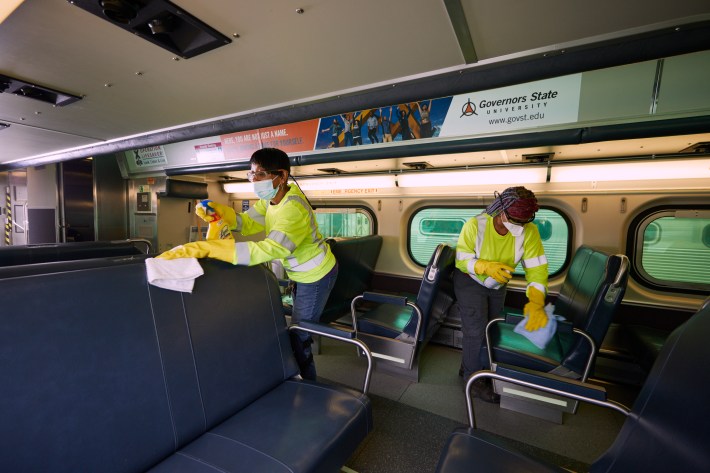 Metra workers clean seats in a rail carriage. Photo: Meta