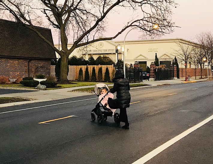 A woman pushes a stroller to Congregation Shaarei Tzedek Mishkan Yair in West Rogers Park at Sundown on a Friday evening. Without the eruv, using the pram would violate Sabbath rules. Photo: John Greenfield
