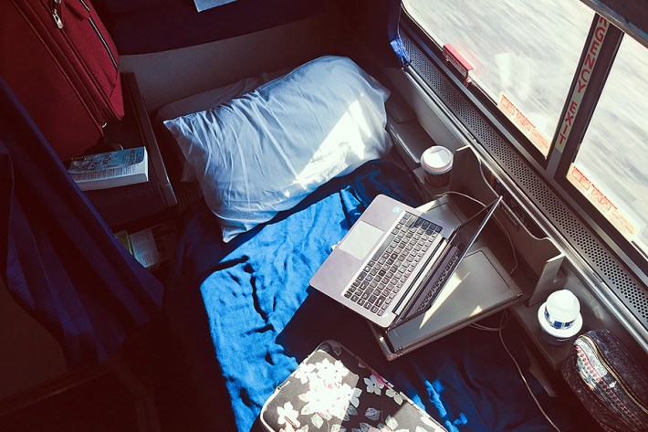 Roomette bed with laptop and suitcase