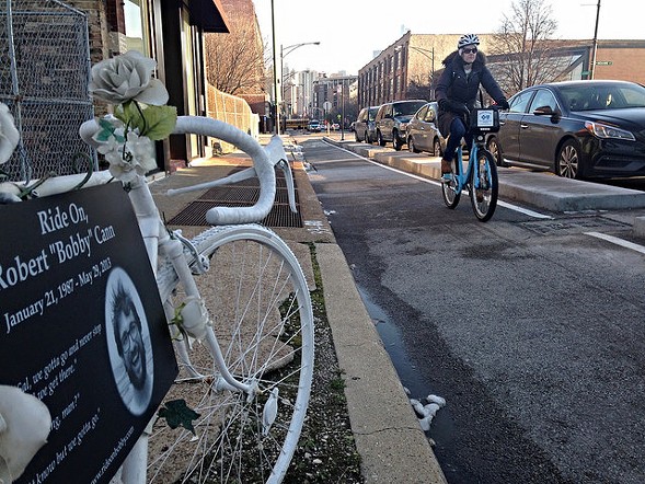 A cyclist rides down the Clybourn protected bike lane, past the "ghost bike" memorial to Bobby Cann. Photo: John Greenfield