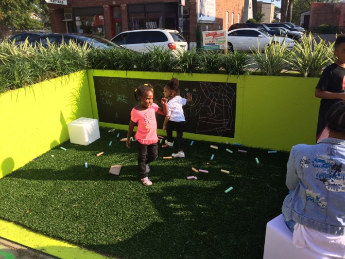 Kids wrote messages on a blackboard in one of the parklets last September. Photo: James Porter