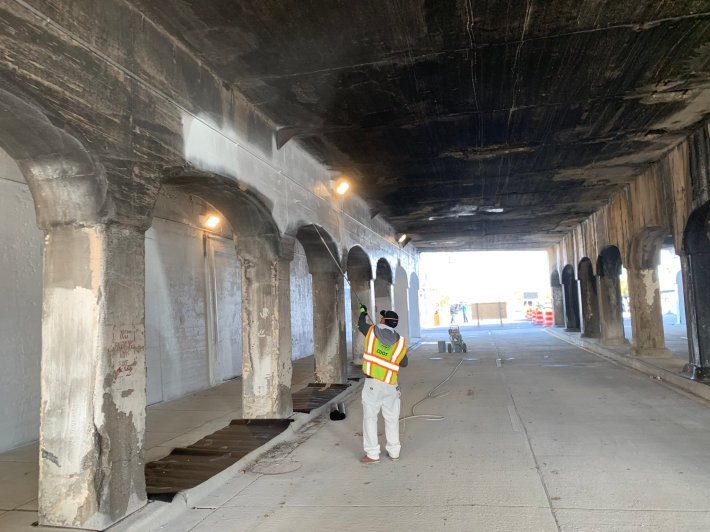 A worker repaints the arches. Photo: CDOT
