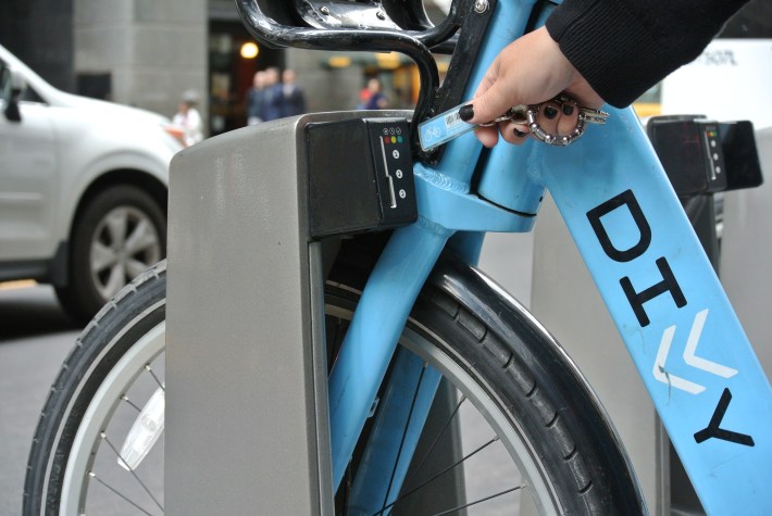 Unlocking a non-electric Divvy at a docking station by inserting the fob in the keyhole of a dock. Photo: CDOT
