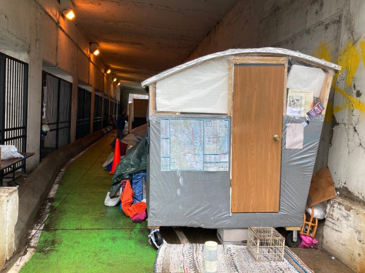 A portable tiny home in the Wilson viaduct with CTA maps. Photo: John Greenfield