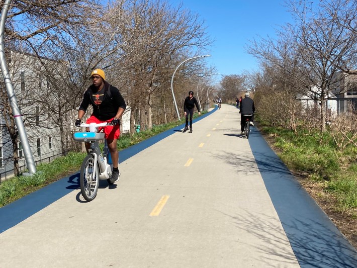 Riding a gray electric bike on the Bloomingdale Trail, aka The 606, last April, when there was no per-minute fee for members to do so. Photo: John Greenfield