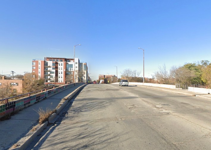Belmont Avenue at the south end of the 312 RiverRun (the opening to an access ramp is visible at the right side of the image) looking west. Image: Google Maps