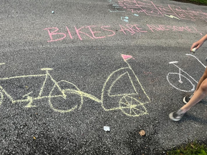 A chalk drawing of a bike with a trailer attached and "Bikes are Awesome" on a street during a recent bike jamPhoto: Chicago Family Biking