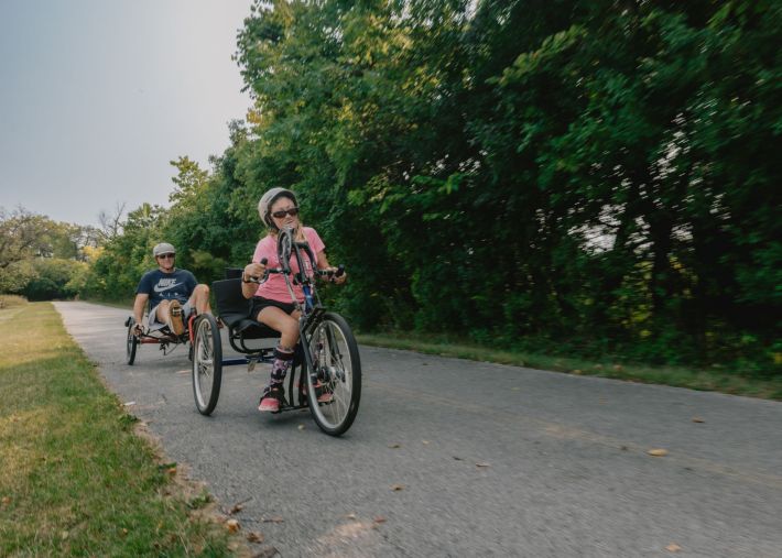 Cyclists using adaptive bikes along a trail.Credit: