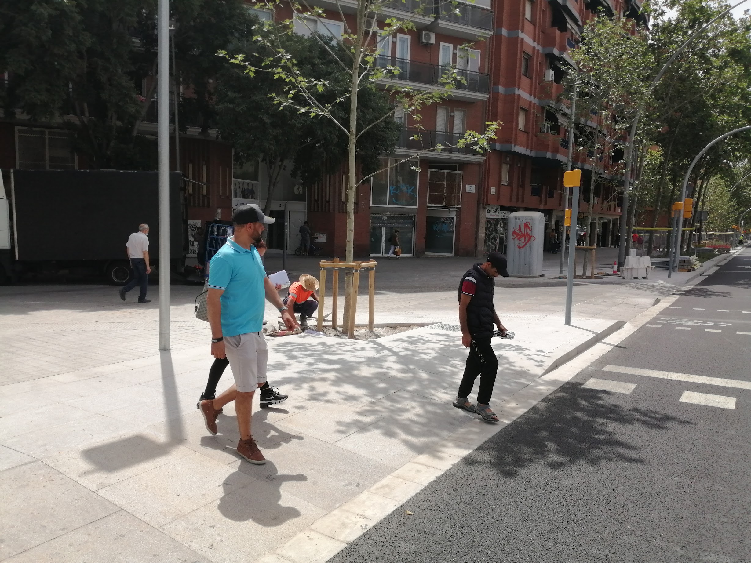 A photo of new pedestrian infrastructure in Barcelona, with three people walking on it.