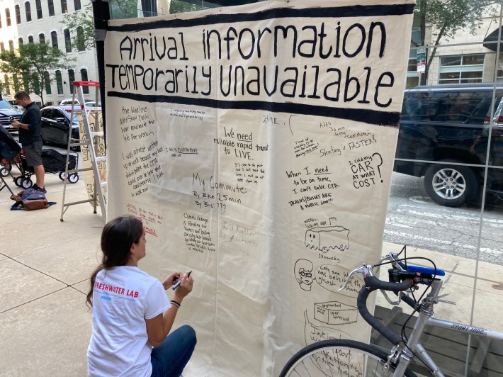 Attendees wrote down comments on an "Arrival Information Temporarily Unavailable" banner on a bus shelter. Photo: John Greenfield