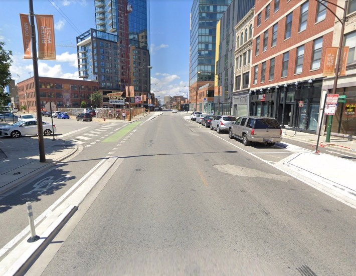 Milwaukee Avenue at Huron Street, looking northwest. The green paint should have reminded left-turning driver to yield to bike riders. Image: Google Maps