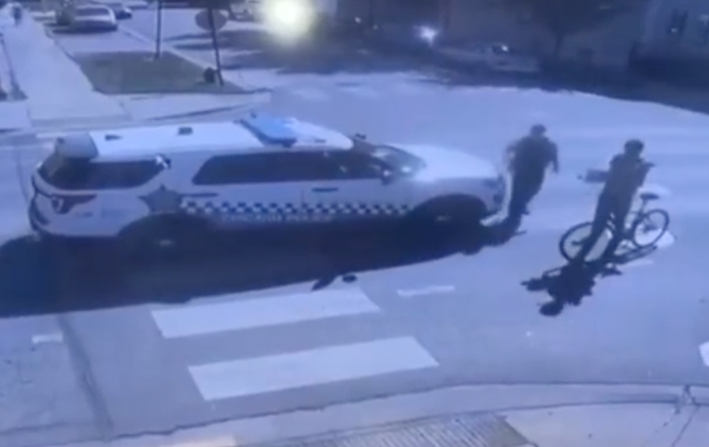 The cop walks towards the bike rider.