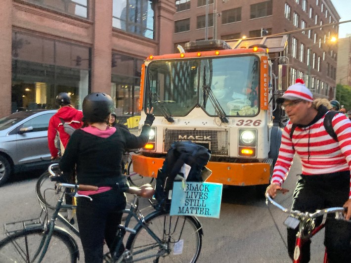 The Deadline publisher (and sometime Streetsblog Chicago proofreader) Elizabeth Tieri "corks" an impatient recycling truck driver on Clinton Street as "Acemann," who runs an unofficial Chicago Critical Mass Twitter account, rides by. Photo: John Greenfield