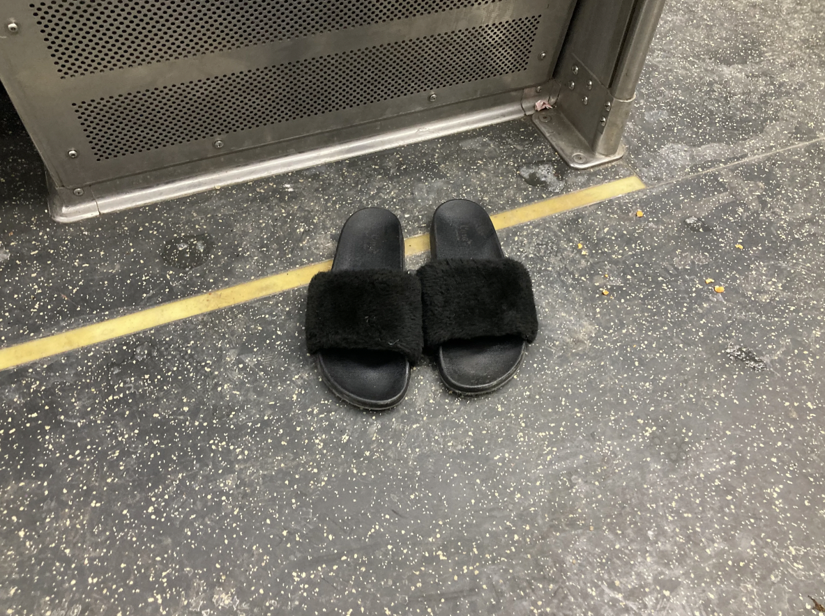 A person sleeping across multiple seats in their stocking feet earlier this year on the Red Line left their sandals on the floor. Photo: John Greenfield