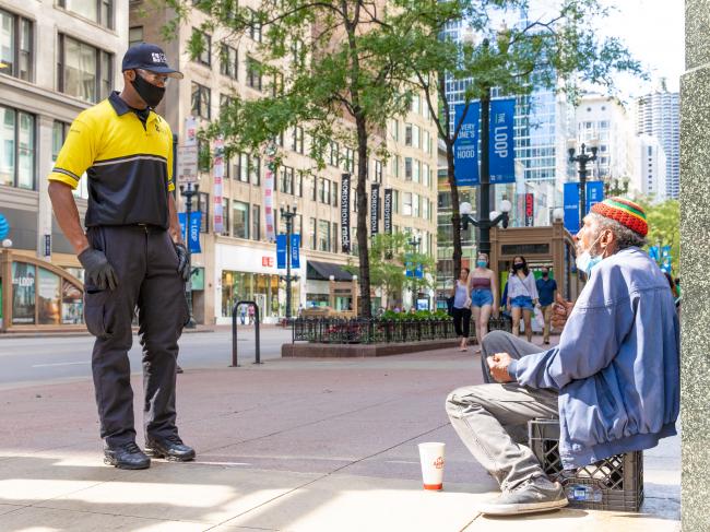A Chicago Loop Alliance Ambassador checks in with a person panhandling on State Street.