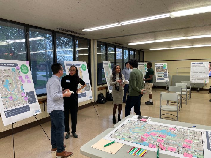 photo of people and posters at the public meeting