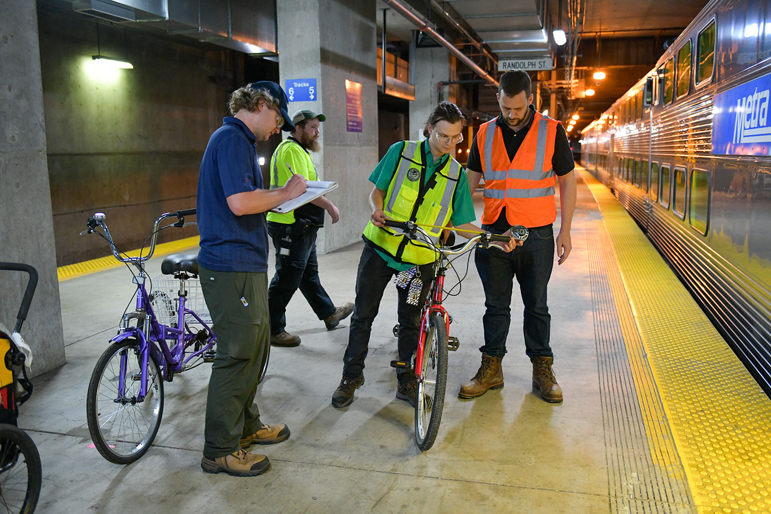 Metra staff measuring different bicycle types at Millennium Station.